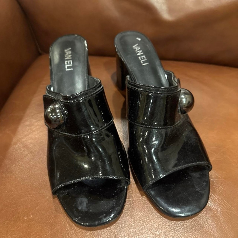 Black patent leather mules with silver buckle detail